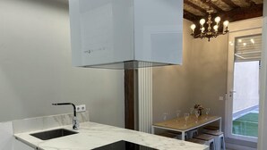 Una cocina moderna con estufa integrada, un lavamanos y una lámpara de araña.