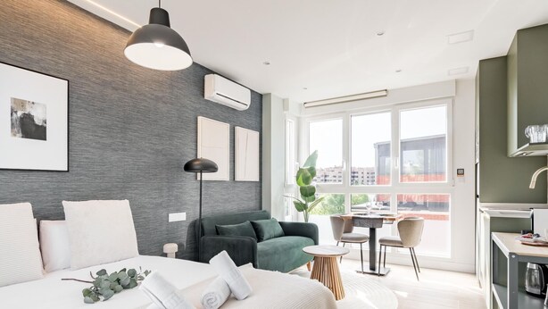 Una habitación de hotel moderna con una cama grande, un escritorio, un sofá y un área de comedor.