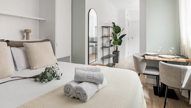 Ett modernt hotellrum med en stor säng, ett skrivbord och en matplats.