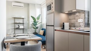 A modern kitchen with a built-in microwave, a stainless steel refrigerator, and a countertop with a coffee machine. - Arturo Soria Stays by Charming VI, renovated with Parking (Madrid)