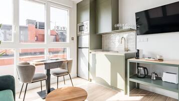 Una cocina moderna con comedor, ventanas amplias y un televisor de pantalla plana.