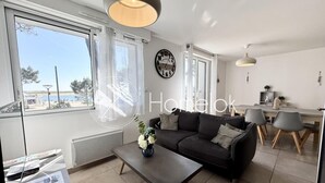 Ein modernes Wohnzimmer mit Sofa, Couchtisch und Essbereich.
