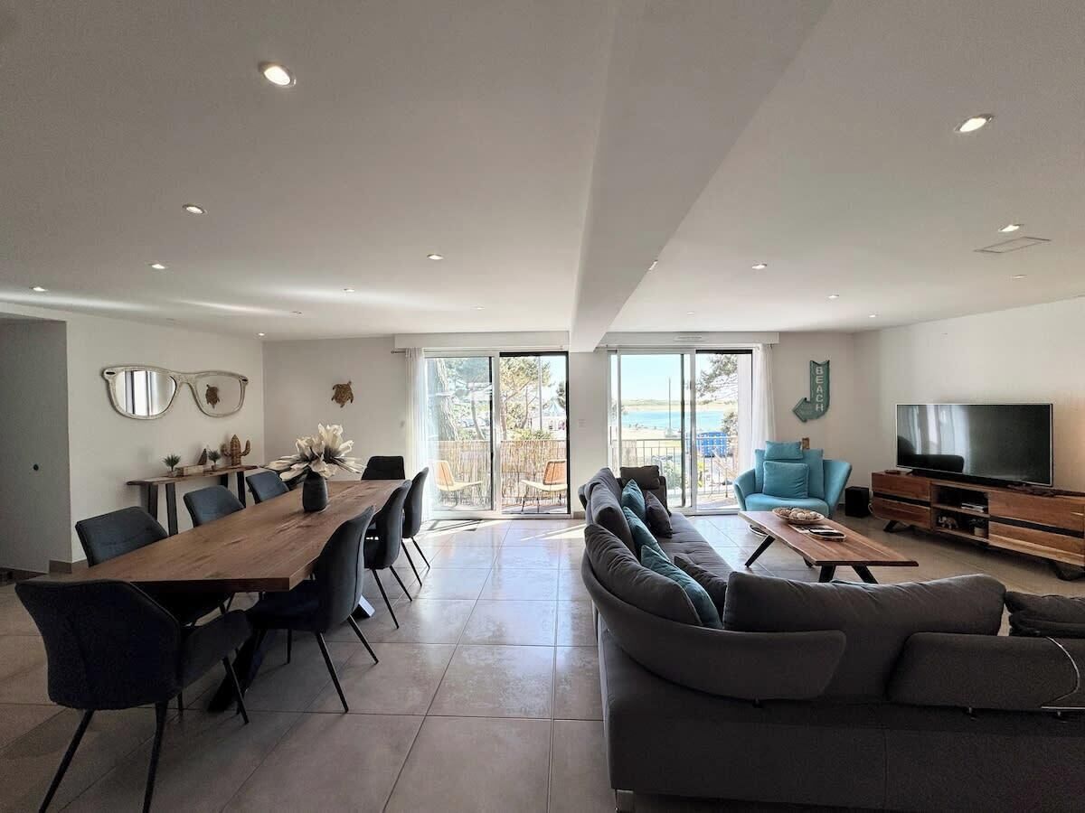 A spacious living area with a dining table, sofas, and a TV.