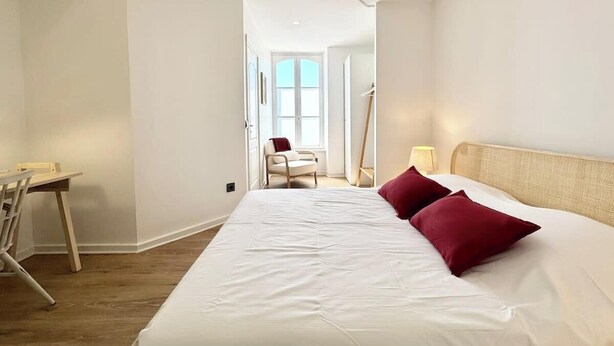 Ein Hotelzimmer mit einem großen Bett, einem Schreibtisch und einem Stuhl.