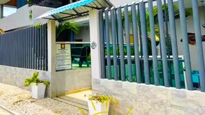A modern building with a gated entrance, a covered outdoor area, and potted plants. - Family Studio Apartment Near the Sea - Coveñas (Coveñas)