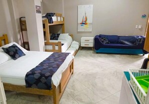 A bedroom with a bed, a bunk bed, a sofa, and a crib.