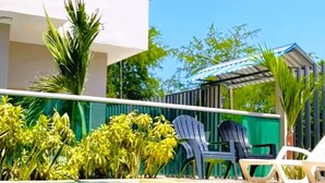 A pool area with clear blue water, surrounded by greenery and modern outdoor furniture. - Family Studio Apartment Near the Sea - Coveñas (Coveñas)
