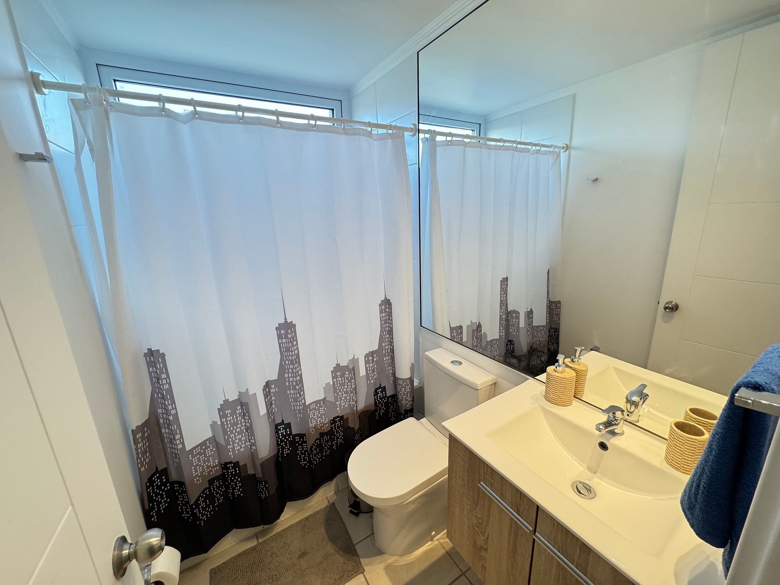 A modern bathroom with a toilet, sink, and mirror.