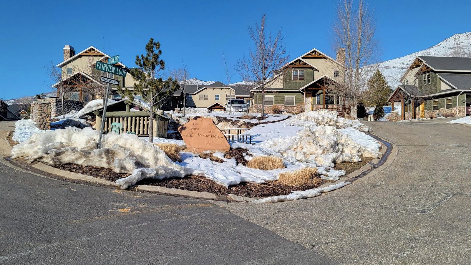 A residential area with houses, a snow-covered landscape, and a sign indicating 'Fairview Loop'.