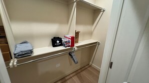 Une salle de bain avec un espace douche, un porte-serviettes et une étagère contenant des articles de toilette.