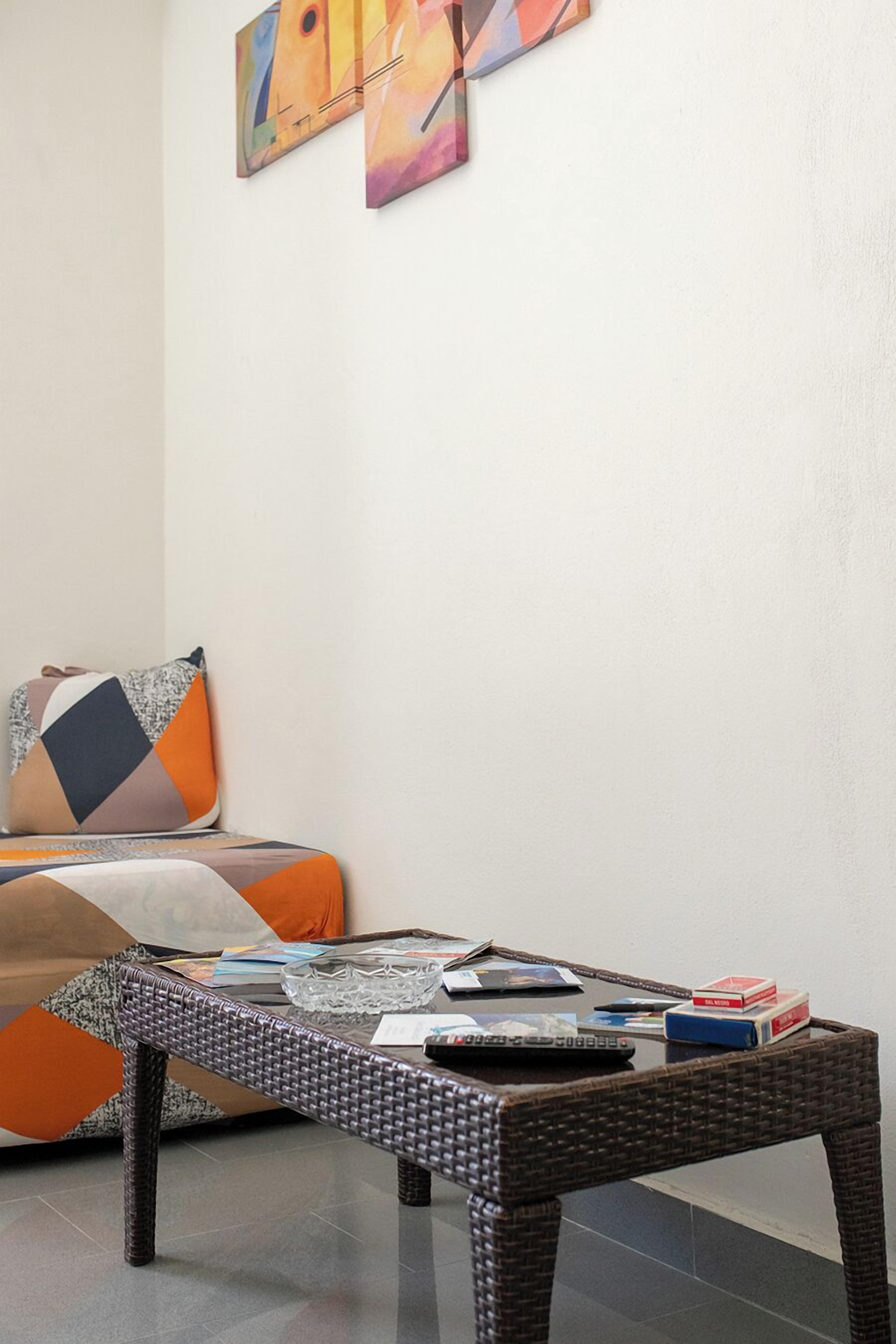 Un salon comprenant un canapé, une table basse et des œuvres d’art abstraites accrochées au mur.