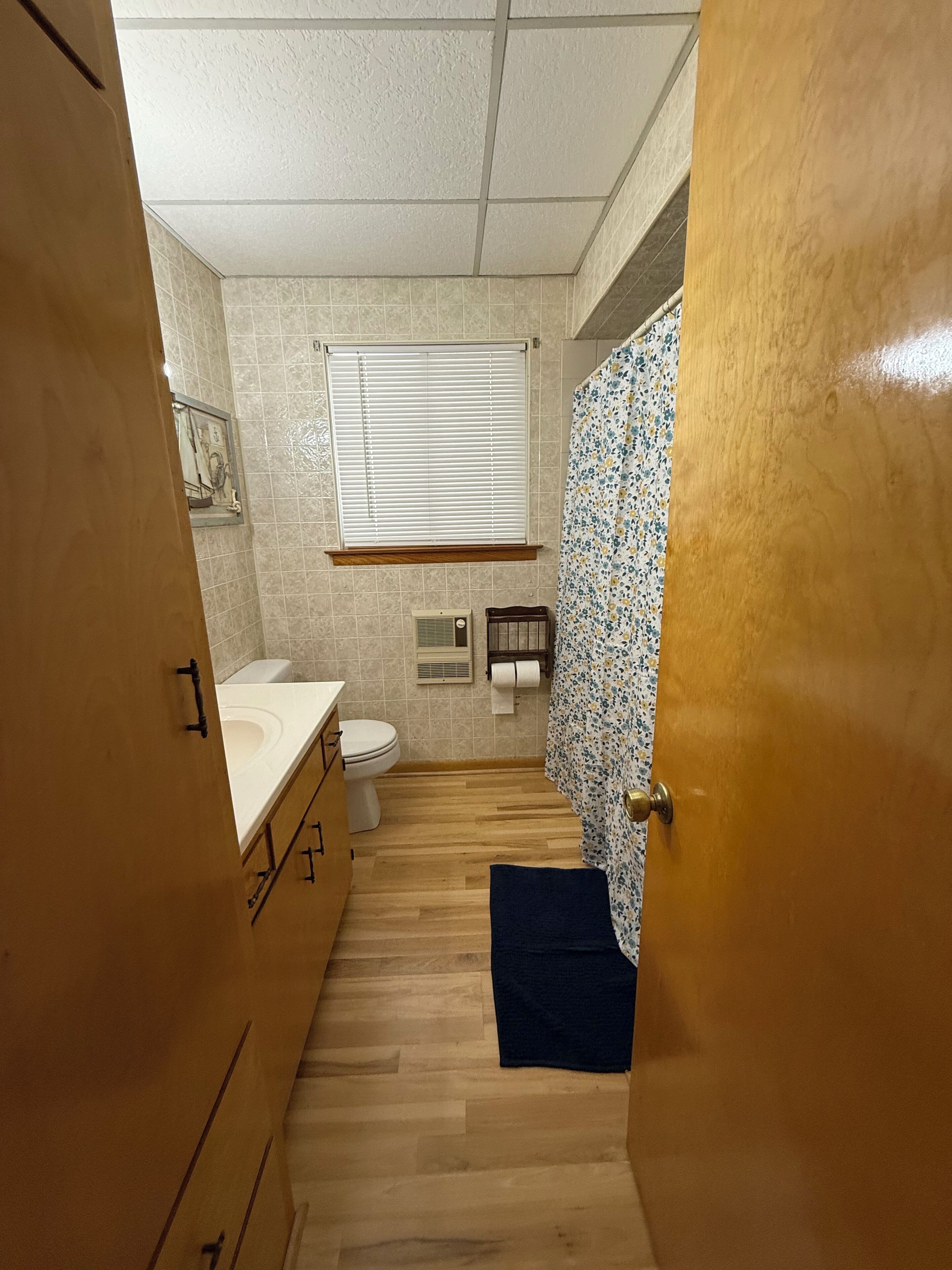 Un baño pequeño con inodoro, lavabo y zona de ducha.