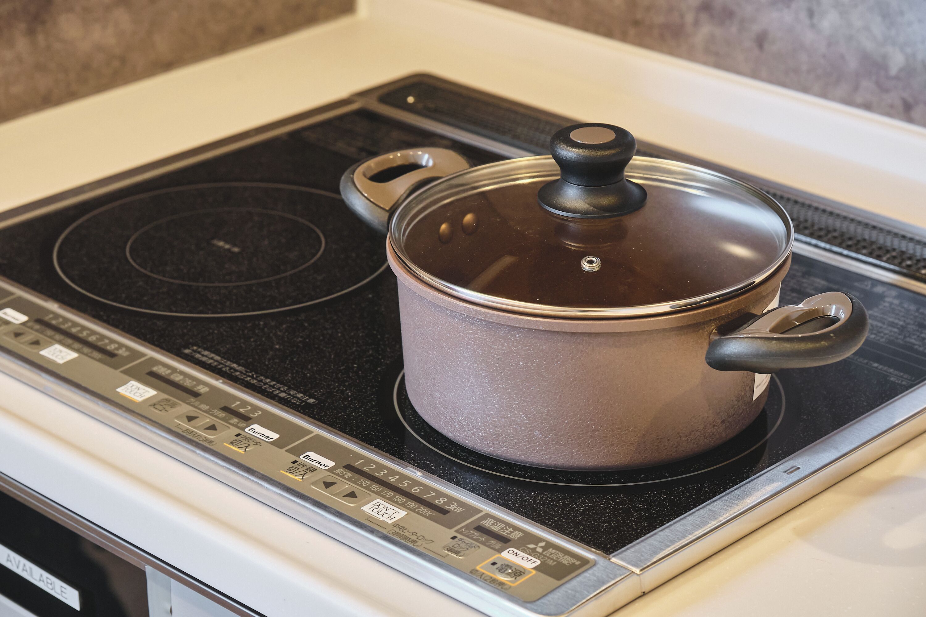 Une cuisine avec un fourneau et une casserole dessus.