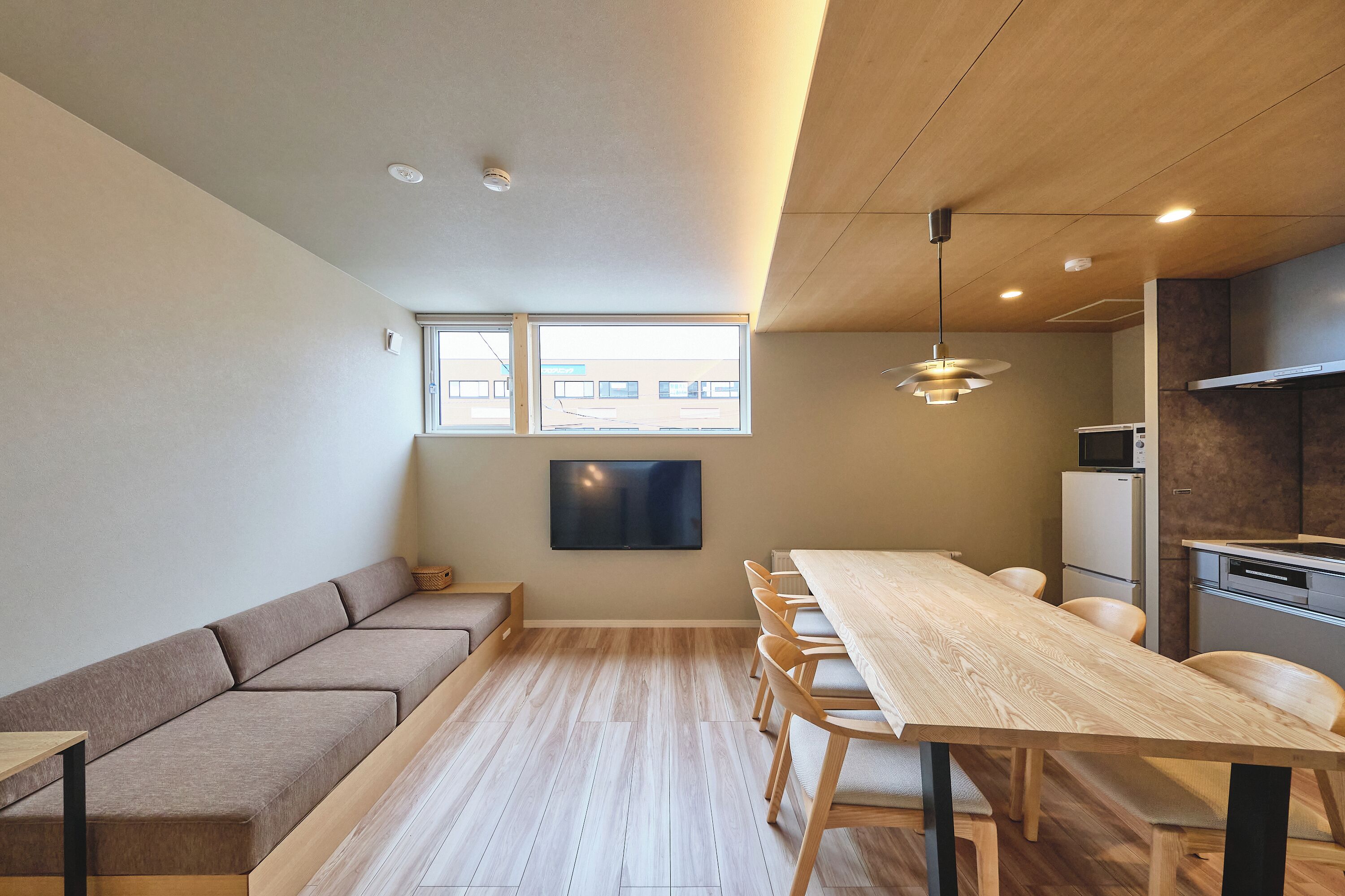 A modern kitchen with a wooden countertop, a built-in oven, and a microwave.