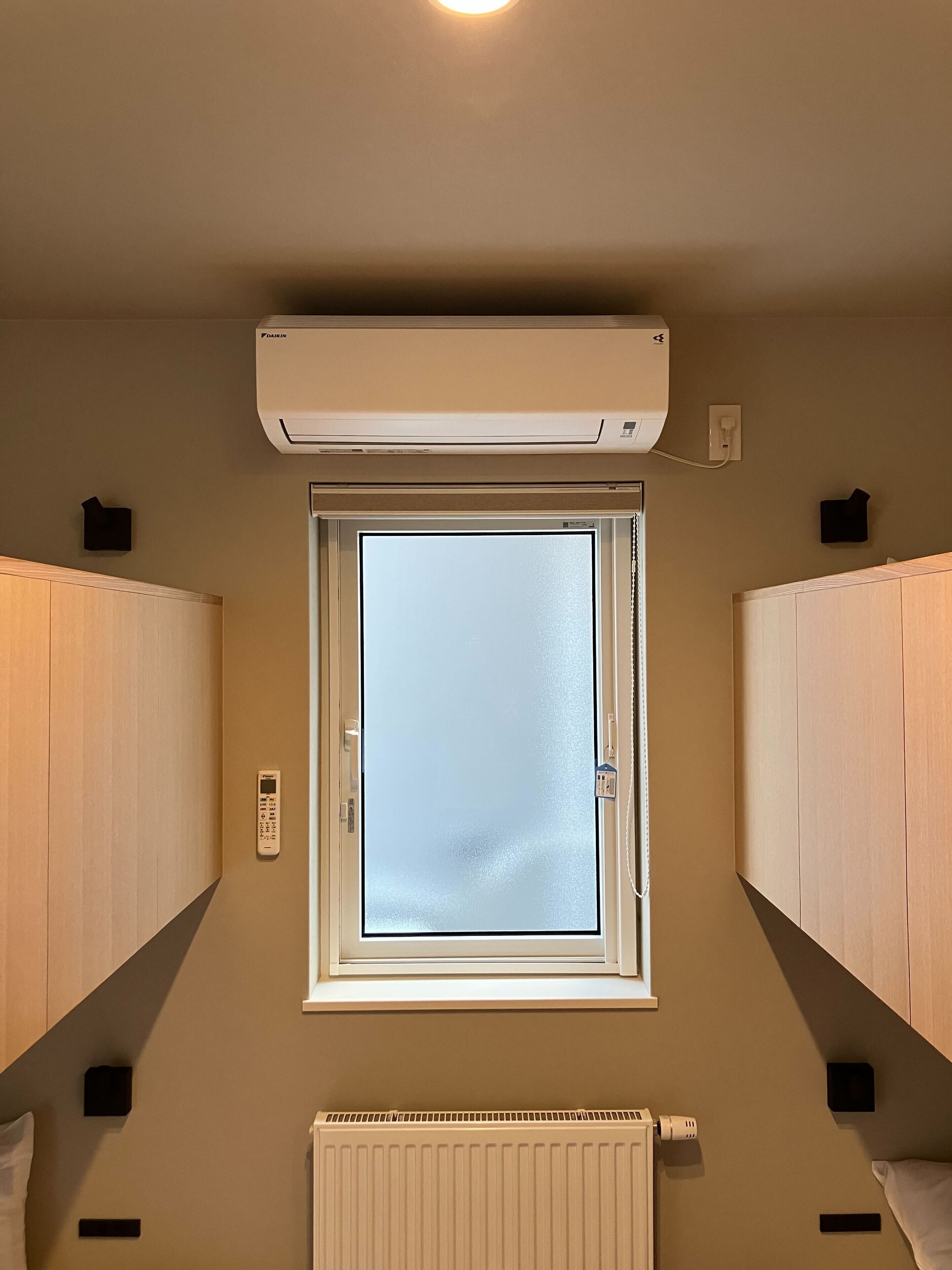 Een kamer met dakraam, een radiator en houten kasten.