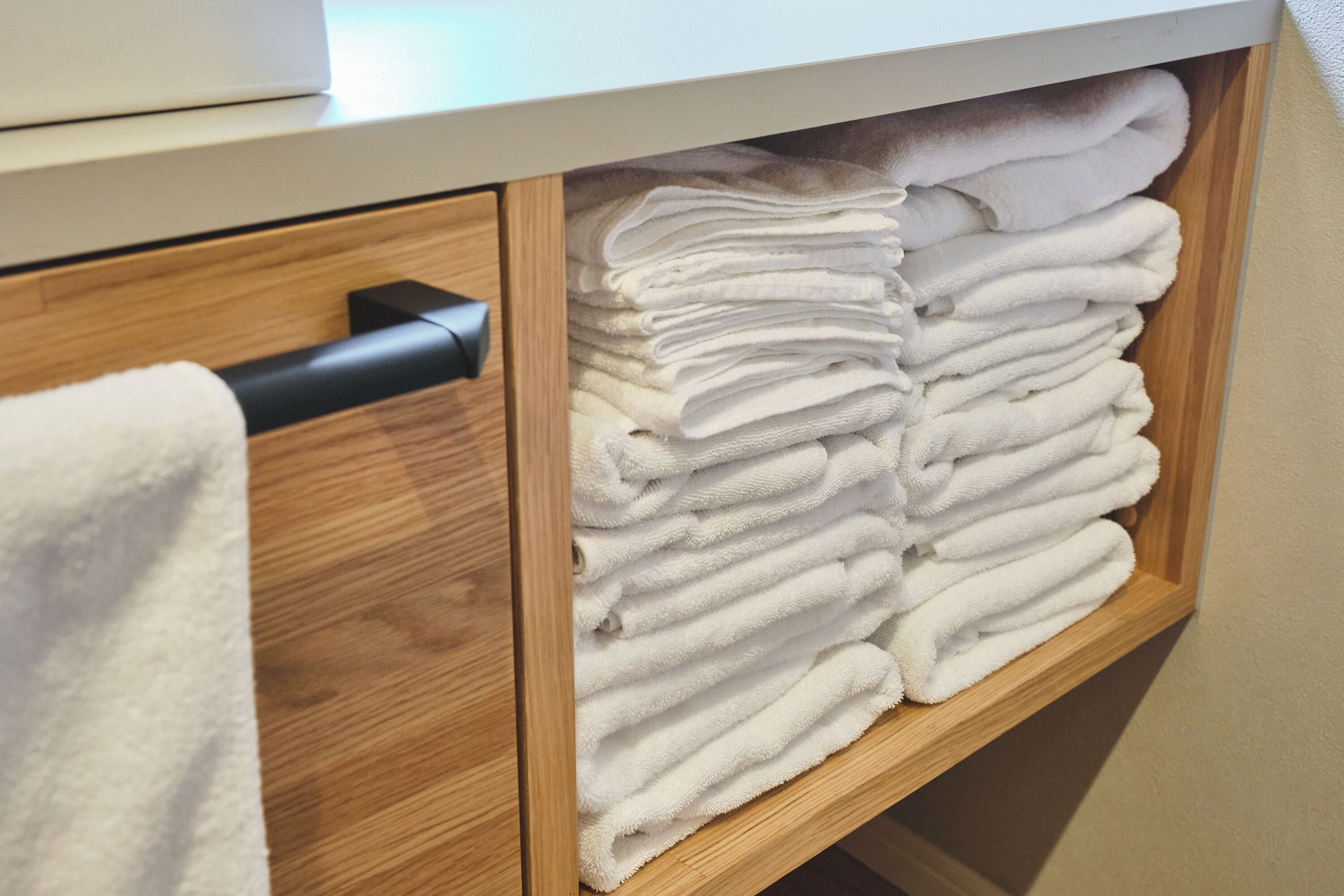 Ein Holzkabinent mit Handtuchhalter und Schublade.