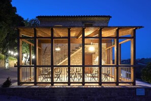 A wooden structure with a balcony, a staircase, and a seating area. - Villa le Moie by MMega (Arcevia)