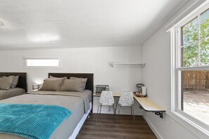 A bedroom with two beds, a desk, and a chair. - Atomic #8 I Downtown I Historic I Trailer Parking (Moab)