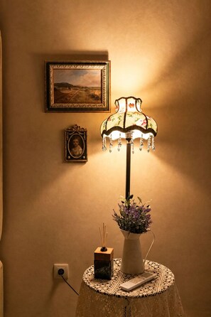 A lamp with a floral design on a table, a framed picture on the wall, and a vase with flowers. - Riad Casa Felicità (Marrakech)
