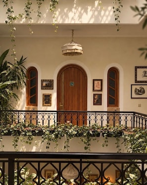 A building facade with a wooden door, arched windows, and a hanging light fixture. - Riad Casa Felicità (Marrakech)