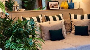 Ein gemütliches Wohnzimmer mit einer Couch, dekorativen Kissen und hängenden Korbtablelampen.