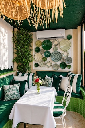 A green-themed room with a dining table, chairs, and a wall decorated with plates. - Riad Casa Felicità (Marrakech)