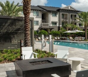 Relax by the fire pit or take a dip in the pool surrounded by lush greenery and palm trees.