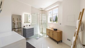 A modern bathroom with a glass shower enclosure, a wooden vanity, and a large window providing natural light. - Modern Apartment - 2br-4p- Croisette Plage (Cannes)
