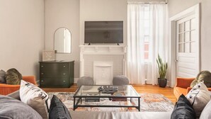 A living room with a fireplace, a television above it, a sofa, and a coffee table.