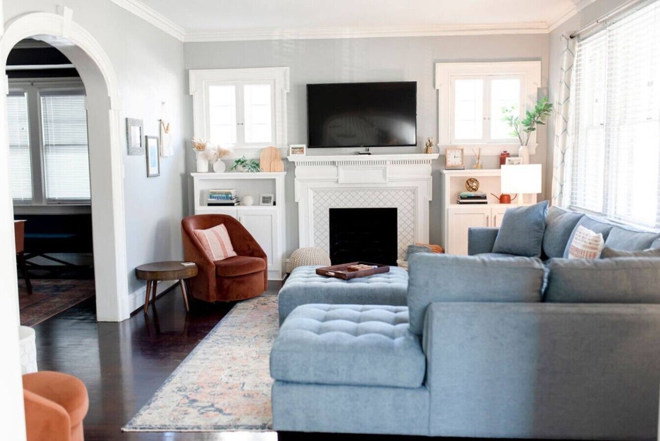 Una sala de estar con chimenea, un sofá grande, un televisor y una mesa de centro.