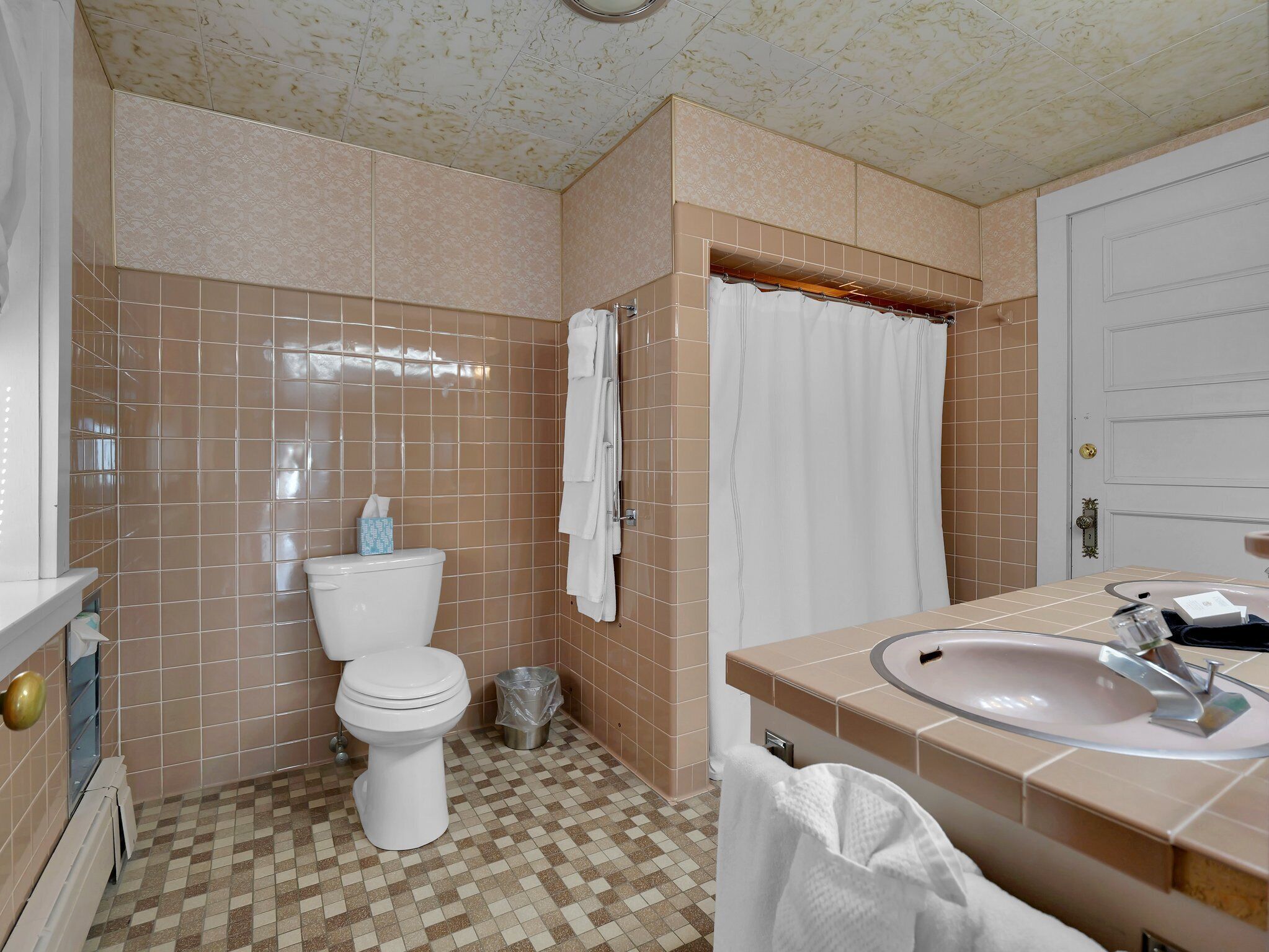 A bathroom with a toilet, sink, and shower curtain.