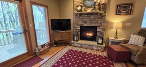 Cozy living room with a fireplace, flat-screen TV, and comfortable seating area.