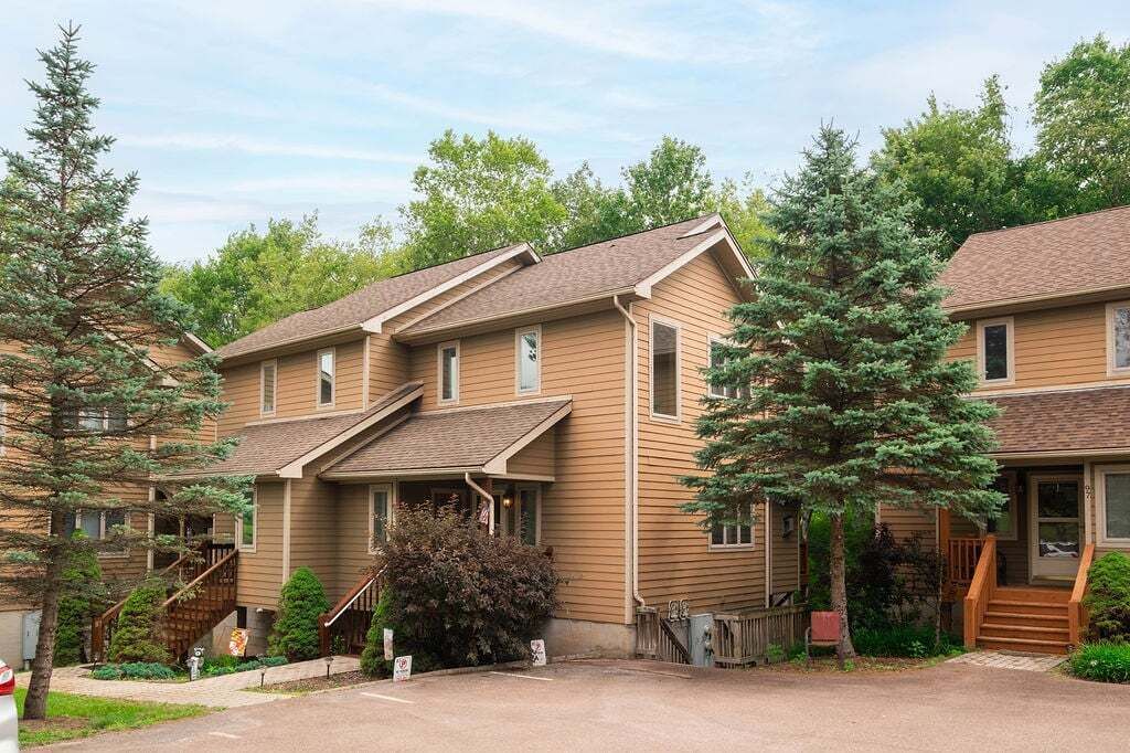A two-story building with a covered front porch and a staircase leading to the entrance.