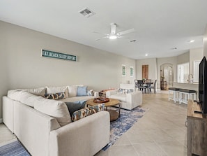 A living room with a sofa, coffee table, and a sign on the wall.