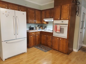 Fully equipped kitchen with refrigerator, stove, and microwave, plus ample countertop space for cooking and preparing meals.