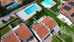 A residential area with two houses, a swimming pool, and solar panels. - Appartamento Gloria by Bookinggardalake (Manerba del Garda)