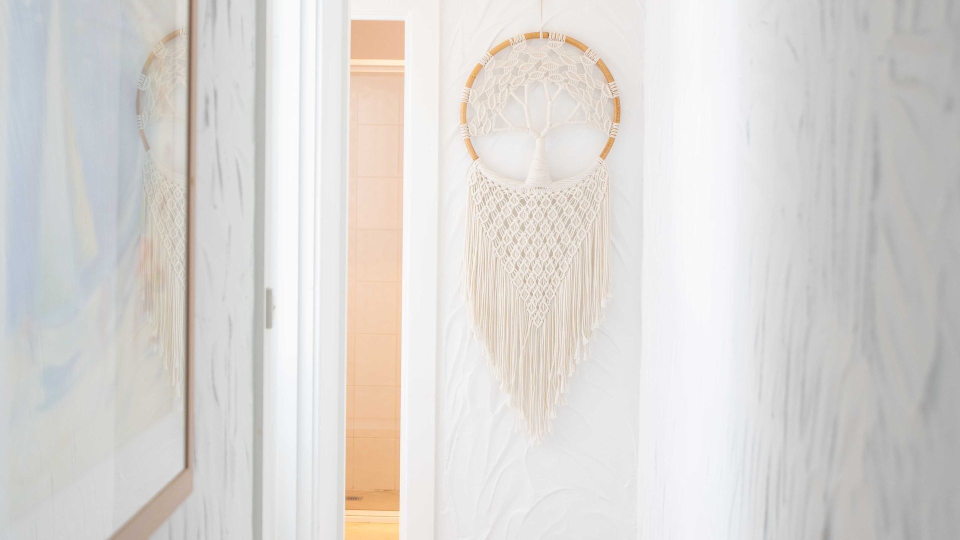 Un couloir orné d’un attrape-rêves et d’un miroir au mur.