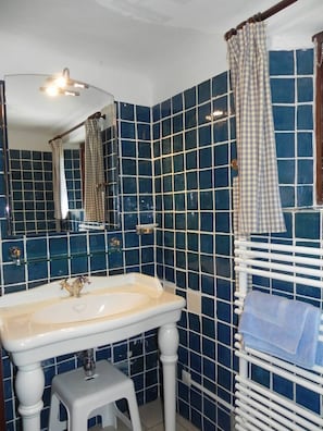 Bathroom features a large sink, mirror, and towel rack.