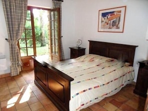 Cozy retreat with a comfortable bed, bedside table, and window with curtains.