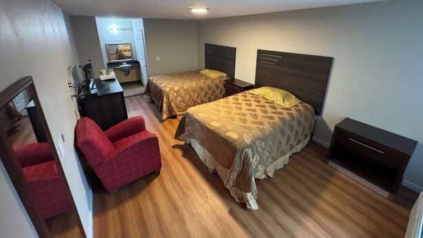 A compact hotel room with two single beds, a small desk, a chair, and a wardrobe. - Vista Motel - Riverside (Riverside)