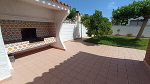 An outdoor patio with a tiled floor, a built-in TV, and a patterned wall. - Villa Recaredo - Chalet con piscina privada en Vinaròs - Ref. 1600 (Vinaròs)