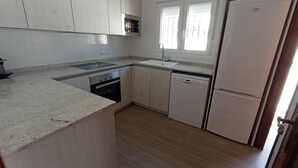 A kitchen with a built-in oven, microwave, sink, and a double-door refrigerator. - Villa Recaredo - Chalet con piscina privada en Vinaròs - Ref. 1600 (Vinaròs)