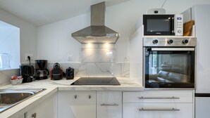 A modern kitchen with a built-in oven, microwave, and coffee maker. - 1 bedroom lovely home in Saujon (Saujon)