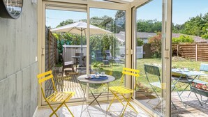 A conservatory with a glass door, a small table, and yellow chairs. - 1 bedroom lovely home in Saujon (Saujon)