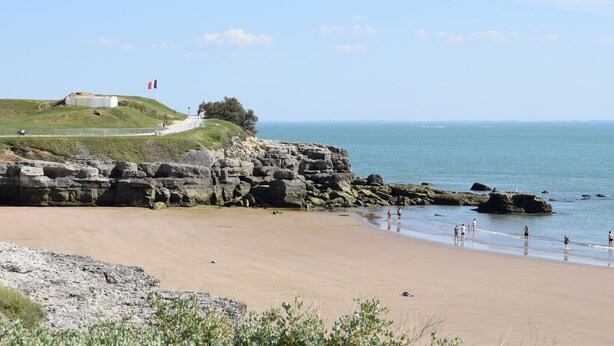 A beach with rocky cliffs, a flag, and a clear sky. - 1 bedroom lovely home in Saujon (Saujon)