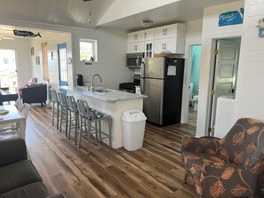 Enjoy meals in the kitchen with a central island, stainless steel sink, and refrigerator, and dine at the table with four chairs.