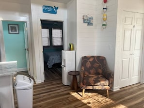 Relax in a cozy space with a seating area and a door leading to a bedroom.
