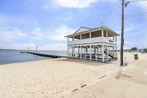 Situated on a sandy beach, this coastal building offers access to the water's edge via a wooden pier.