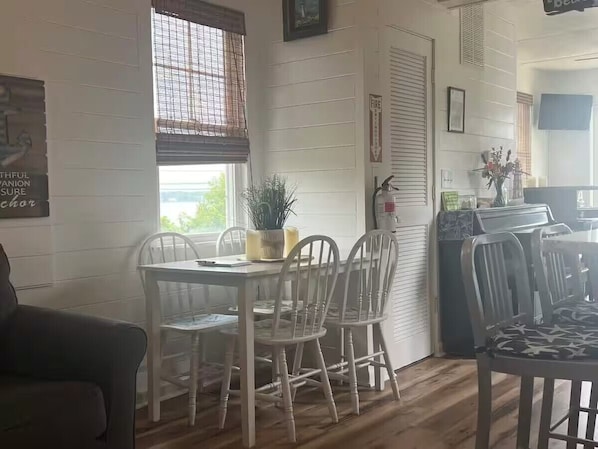 Un comedor con una mesa y sillas, una planta en maceta y un extintor en la pared.