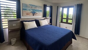 Una camera da letto con un letto grande, un comodino, una mensola a parete e un lampadario.